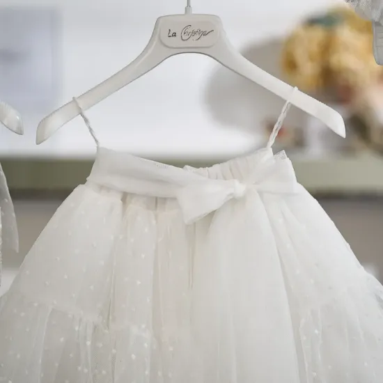 Η φούστα αποτελείται από πολλαπλές στρώσεις τούλι με κεντημένο πουά μοτίβο